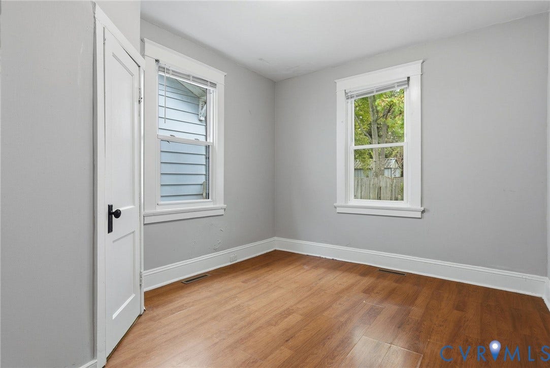 Wood-finish flooring, white trim, and light gray wall paint