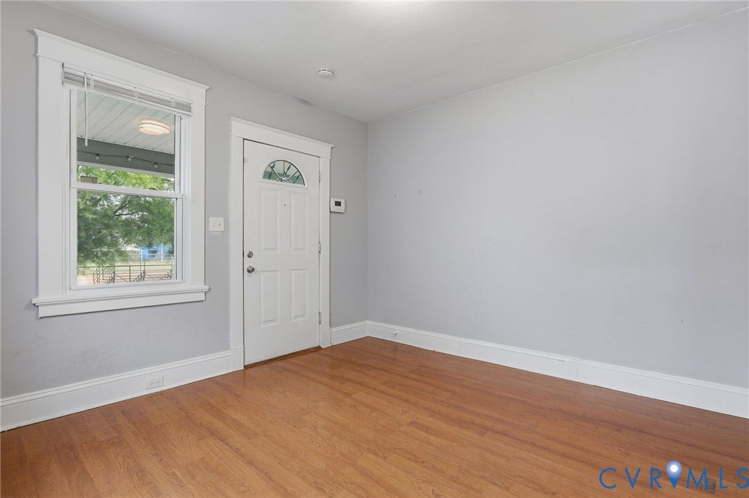 Wood-finish flooring with white trim and light gray walls