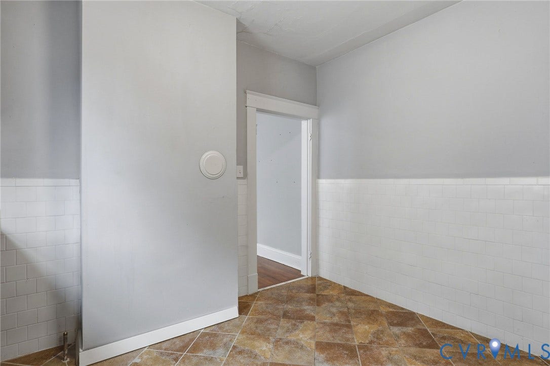 Light grey wall paint with white wainscoting and neutral-toned tile flooring
