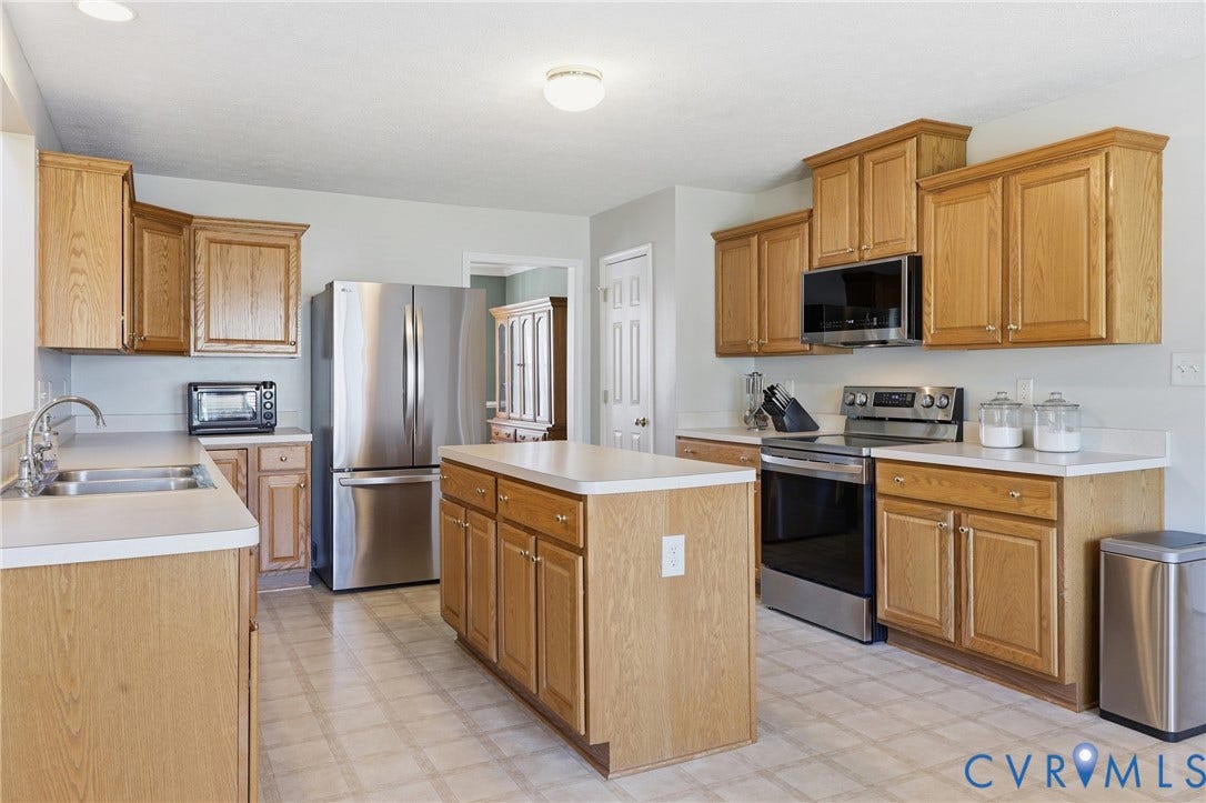 Enjoy an inviting kitchen layout with generous counterspace, center island, stainless steel appliances, and a pantry for extra storage