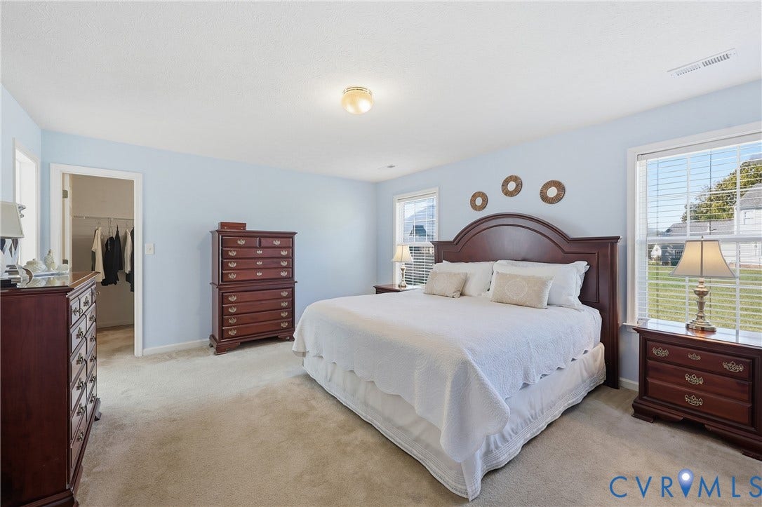 A main-level primary bedroom offers a convenient layout with a private bathroom and generous closet storage