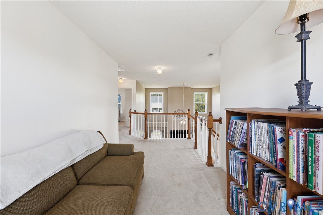 Open upstairs sitting area overlooking the living room, ideal for a reading nook, study, or home office