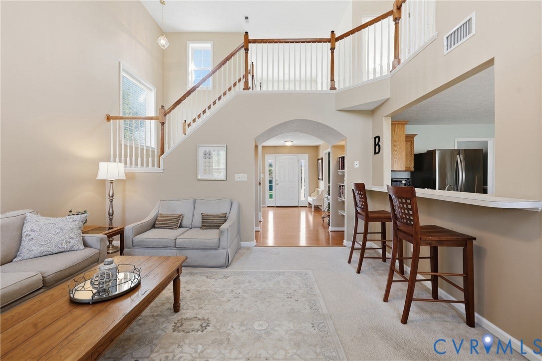 An airy living room brings everyone together with soaring cathedral ceilings and ample natural light