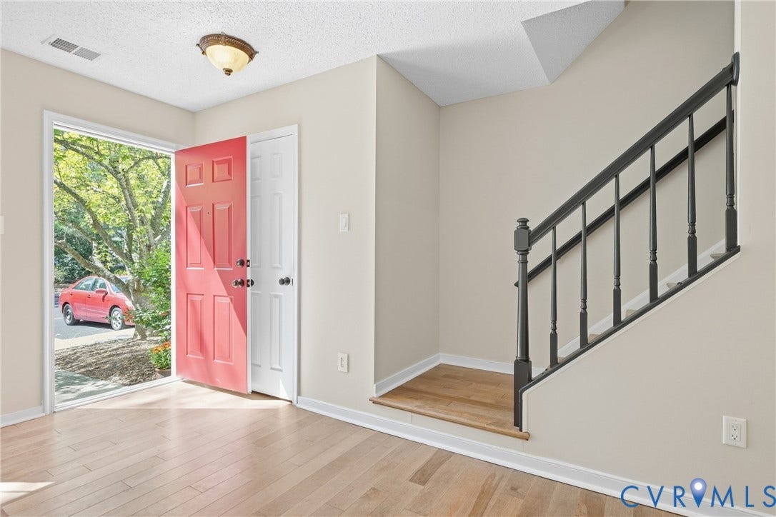 1852 Timberly Waye, Henrico, VA 23238 Entryway featuring a red paneled front door, light wood-finish flooring, and a dark wood banister