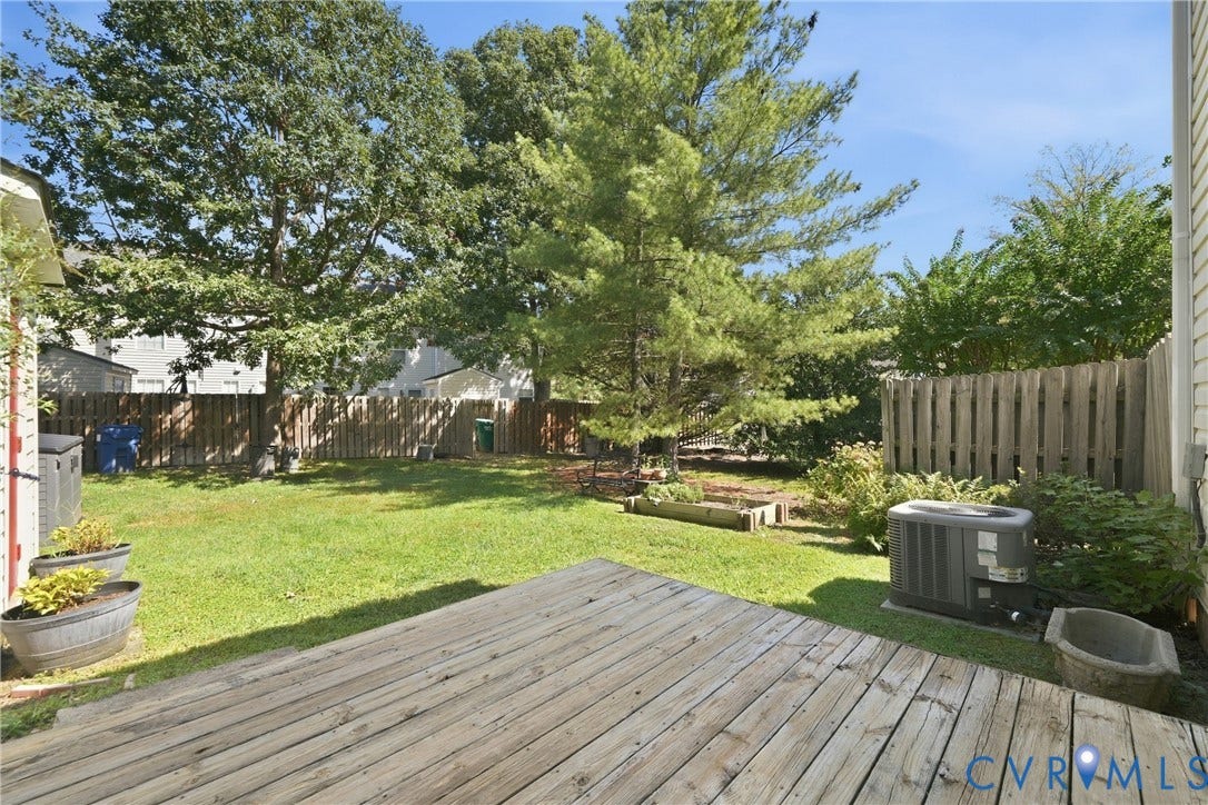 1852 Timberly Waye, Henrico, VA 23238 Expansive wooden deck overlooking a grassy yard with mature trees and a wooden privacy fence