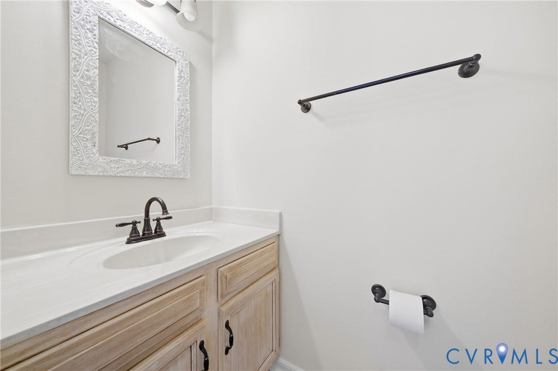 1852 Timberly Waye, Henrico, VA 23238 Vanity with light wood-finish cabinetry, integrated sink, and bronze faucet