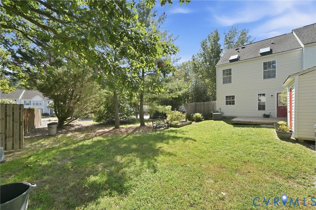 1852 Timberly Waye, Henrico, VA 23238 Expansive fenced backyard featuring a wood deck, manicured lawn, and mature trees
