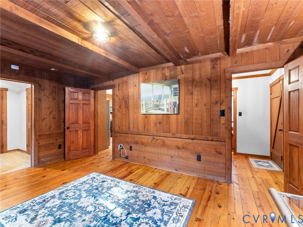3801 Old River Trail, Powhatan, VA 23139 Interior space featuring natural wood-finish flooring, wood-paneled walls, exposed wood ceiling beams, and solid wood interior doors