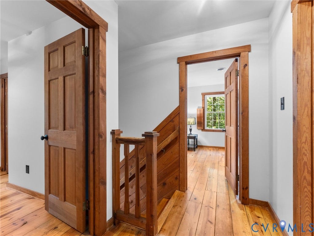 3801 Old River Trail, Powhatan, VA 23139 Wide-plank wood flooring, natural wood-trim door casings, six-panel wood doors, and a wood-slat staircase railing