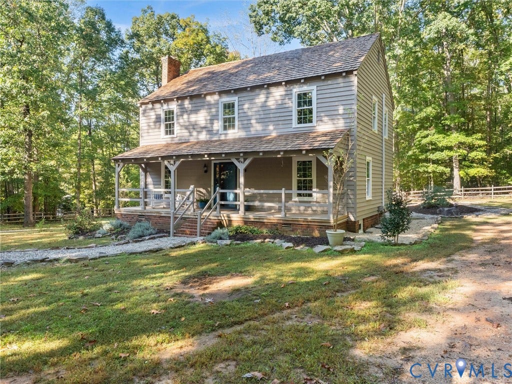 3801 Old River Trail, Powhatan, VA 23139 Two-story residence with horizontal siding, a prominent wood-shake roof, a full-length covered front porch with timber posts, and a decorative brick foundation