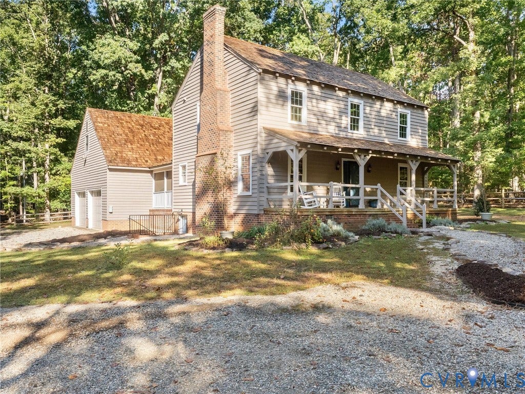 3801 Old River Trail, Powhatan, VA 23139 Two-story siding exterior featuring a wrap-around covered porch, brick chimney, wood-shingle roof, and attached two-car garage