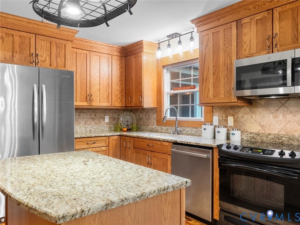 3801 Old River Trail, Powhatan, VA 23139 Kitchen featuring oak cabinetry, stone countertops, stainless steel appliances, a central island, and a tile backsplash