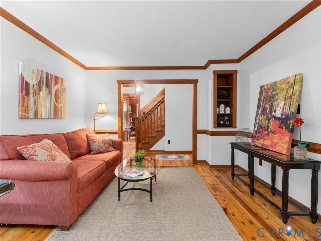 3801 Old River Trail, Powhatan, VA 23139 Living area featuring wood-finish flooring, natural wood crown molding, chair rail, and a built-in recessed wooden shelving unit