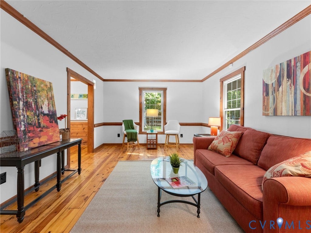 3801 Old River Trail, Powhatan, VA 23139 Living space featuring wood-finish flooring, natural wood crown molding, chair rail trim, and multi-pane windows with wood-finished casings