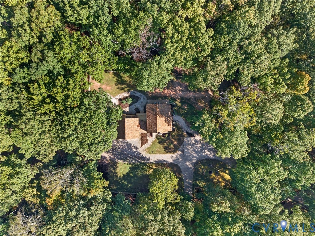 3801 Old River Trail, Powhatan, VA 23139 Aerial perspective of a multi-section residence featuring a brown shingle roof, a paved circular driveway, and a stone-paver walkway, all situated within a heavily wooded lot