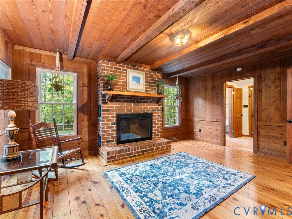 3801 Old River Trail, Powhatan, VA 23139 Interior space featuring natural wood paneling, wood-finish flooring, exposed ceiling beams, and a brick fireplace with a wood mantel