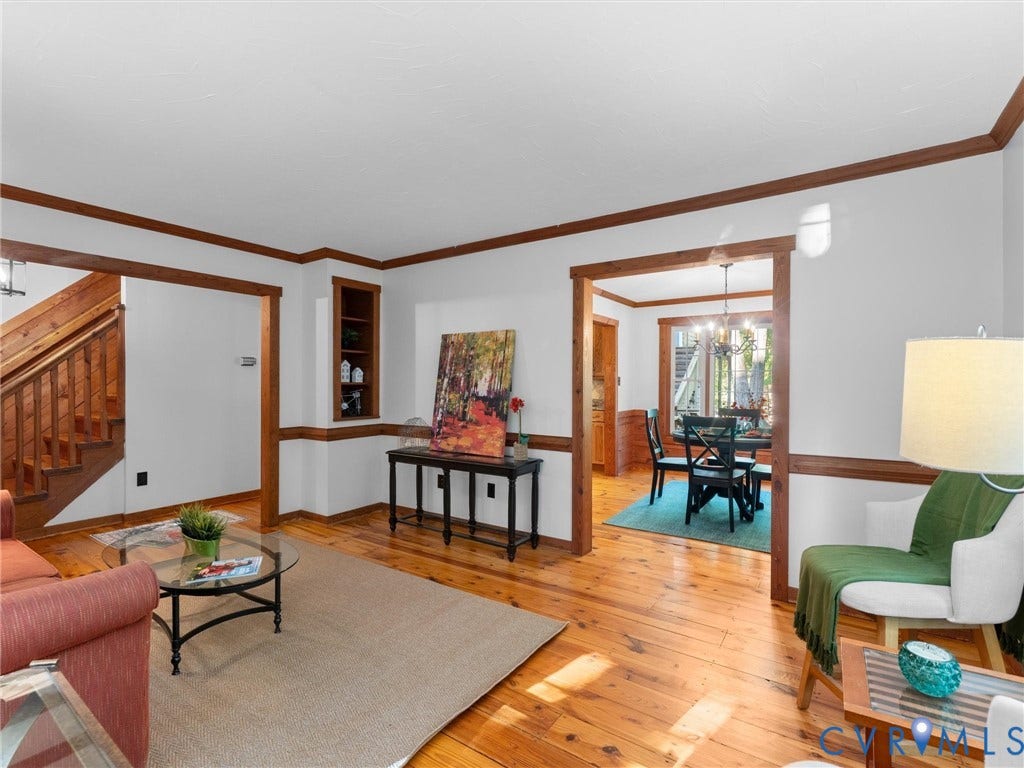 3801 Old River Trail, Powhatan, VA 23139 Elegant living space showcasing rich wood-finish flooring, exposed wood beams, and white walls throughout