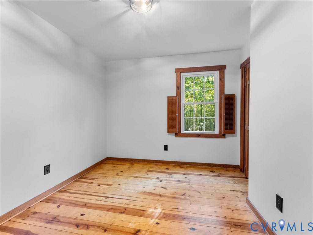 3801 Old River Trail, Powhatan, VA 23139 Natural wood plank flooring, window with wood trim, decorative wooden shutters, and a closet with a wood-finish door