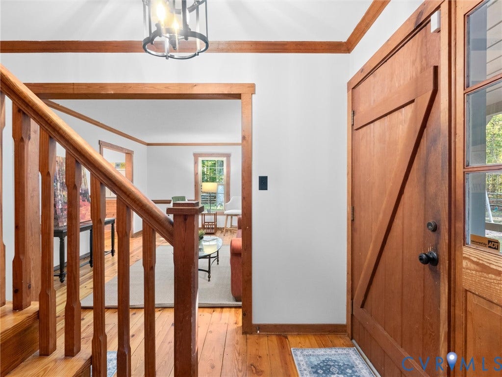 3801 Old River Trail, Powhatan, VA 23139 Entryway featuring wood-finish flooring, natural wood door with Z-brace detailing, multi-pane side light, wood staircase balustrade, and a multi-light ceiling fixture