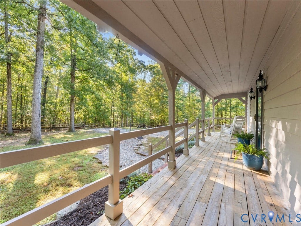 3801 Old River Trail, Powhatan, VA 23139 Covered porch featuring natural wood decking, wooden post-and-rail balustrades, tongue-and-groove ceiling paneling, and wall-mounted exterior lanterns