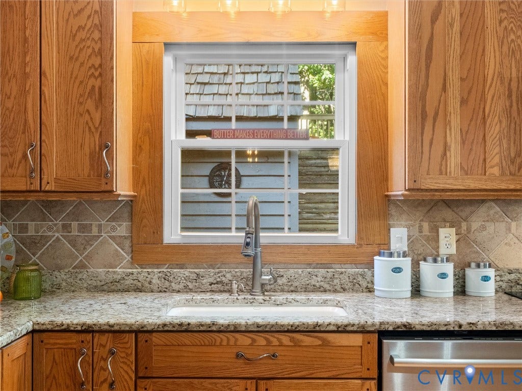 3801 Old River Trail, Powhatan, VA 23139 Kitchen featuring light-toned cabinetry, stone-finish countertops, tile backsplash, and a double-hung window framed in wood molding with a high-arch pull-down faucet
