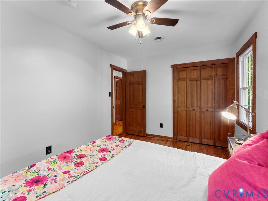 3801 Old River Trail, Powhatan, VA 23139 Room featuring wood-finish flooring, stained wood interior doors, wood-trimmed window casing, bi-fold closet doors, and a ceiling fan with integrated lighting