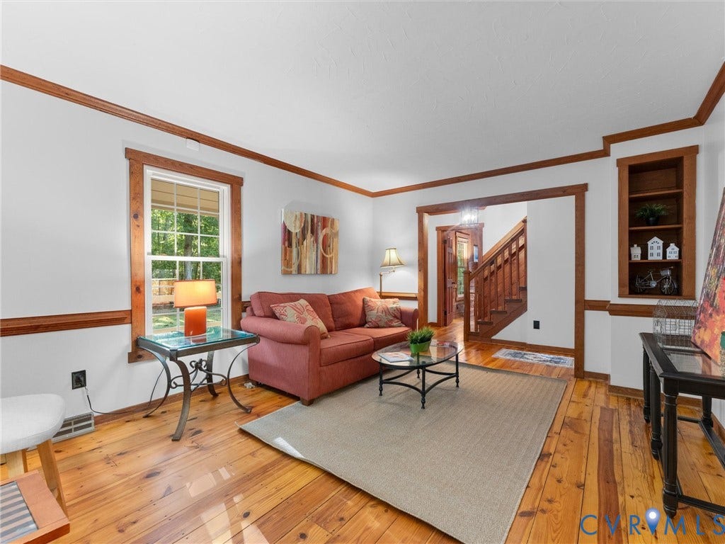 3801 Old River Trail, Powhatan, VA 23139 Living area featuring natural wood flooring, crown molding, chair rail trim, built-in shelving, and wood window casing