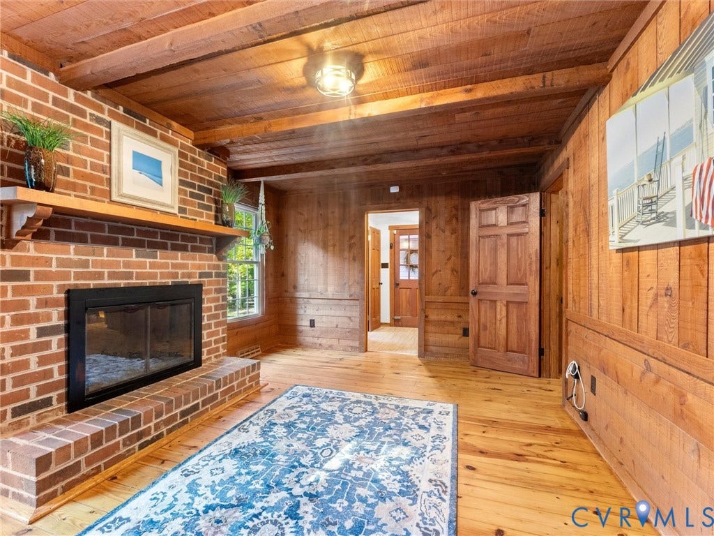 3801 Old River Trail, Powhatan, VA 23139 Exposed beam ceiling, full-height wood paneling, and masonry fireplace featuring a wood mantelpiece and raised hearth
