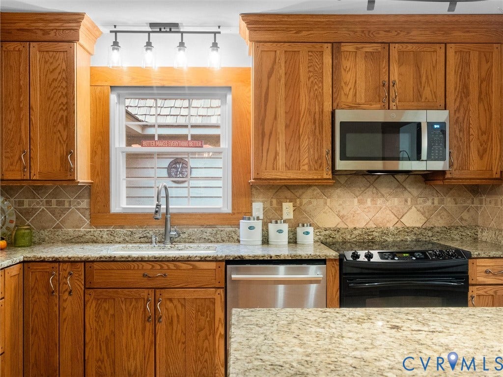 3801 Old River Trail, Powhatan, VA 23139 Kitchen featuring wood cabinetry, stone countertops, diamond-pattern tile backsplash, stainless steel appliances, and a single-handle pull-down faucet