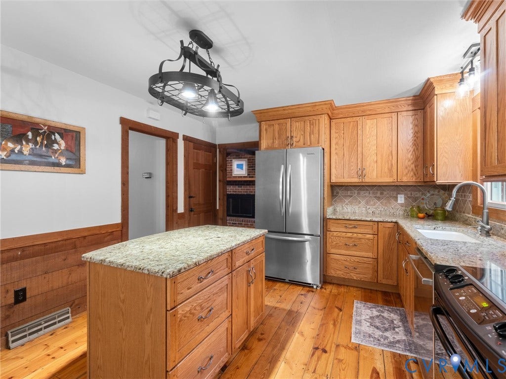 3801 Old River Trail, Powhatan, VA 23139 Kitchen featuring custom wood cabinetry, natural stone countertops, a center island, stainless steel refrigerator, and wood flooring