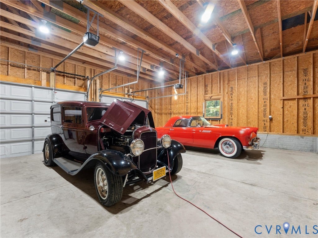 3801 Old River Trail, Powhatan, VA 23139 Multi-car garage featuring exposed wood framing, concrete flooring, dual automatic door openers, and high-output overhead lighting