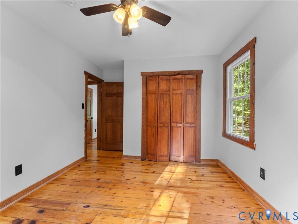 3801 Old River Trail, Powhatan, VA 23139 Room featuring natural wood-finish plank flooring, wood-framed window, bi-fold wooden closet doors, and a ceiling-mounted light fixture with four-blade fan