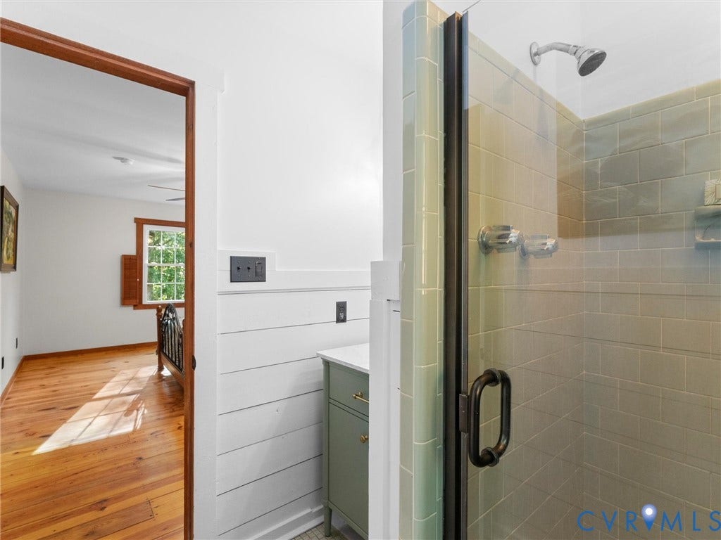 3801 Old River Trail, Powhatan, VA 23139 Glass-enclosed shower with subway tile surround, white shiplap wall paneling, and vanity with a stone countertop