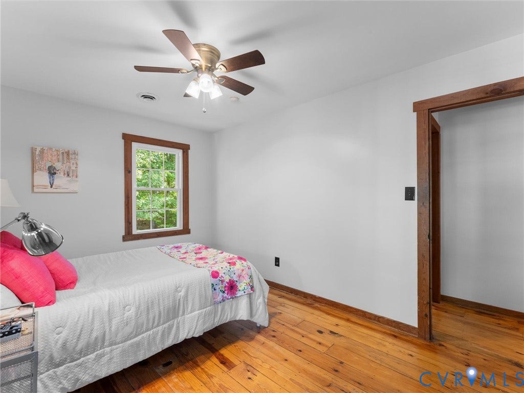3801 Old River Trail, Powhatan, VA 23139 Natural wood-finish flooring, dark wood trim surrounding the window and doorway, and a multi-light ceiling fan