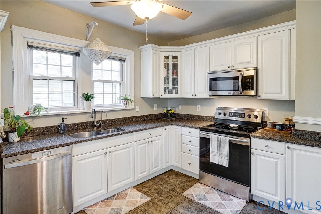 White cabinetry with crown molding, granite-style countertops, and stainless steel appliances