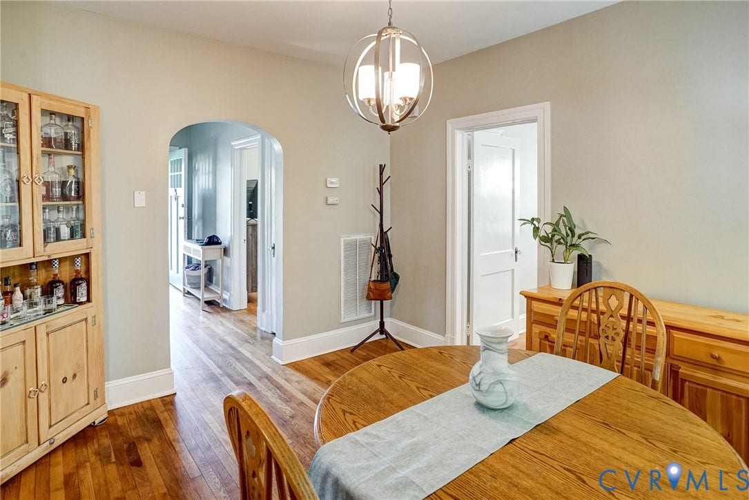 Hardwood flooring, arched doorway, and a modern orb-style pendant light fixture