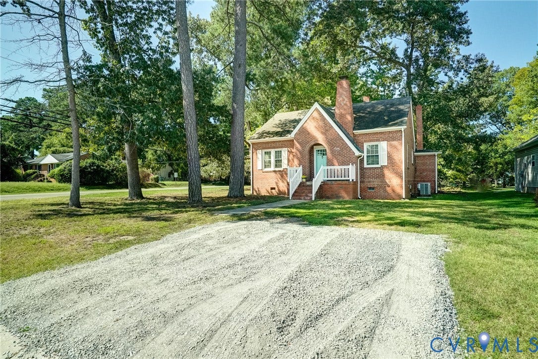 Brick exterior residence with a prominent chimney, front entry porch, and white railing