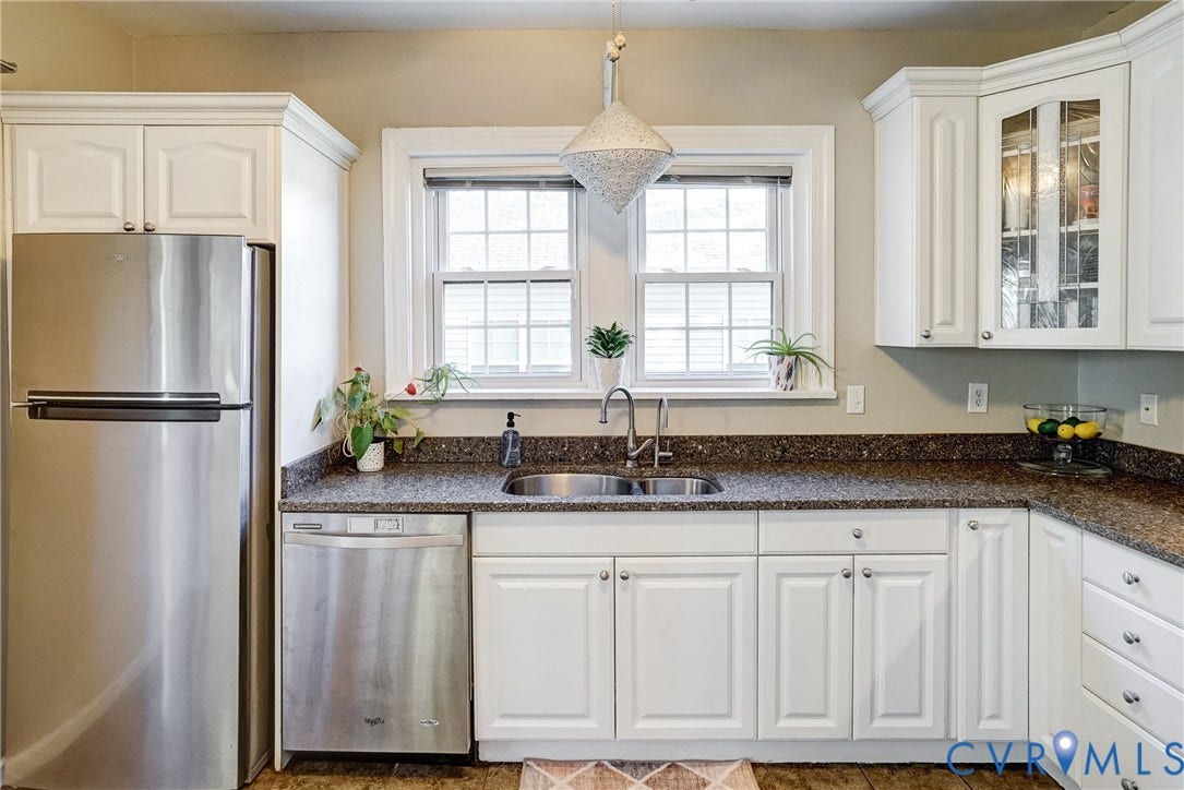 White cabinetry, stainless steel appliances, speckled countertops, corner glass-front cabinet, and a stainless steel sink with a gooseneck faucet