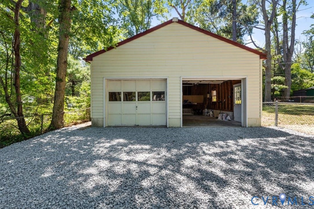 1215 Starling Drive, Henrico, VA 23229 Detached garage with two bays, one featuring an overhead door with windows and the other an open bay with a side entry door