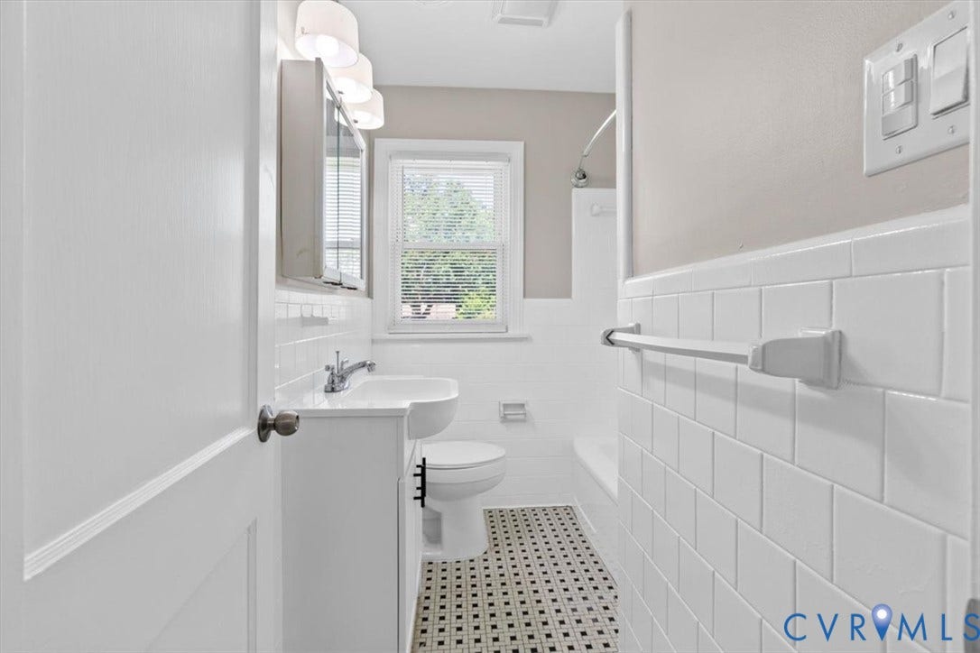 1215 Starling Drive, Henrico, VA 23229 Bathroom featuring white subway tile walls, black and white mosaic floor tiling, a white vanity with an integrated sink, and a built-in medicine cabinet