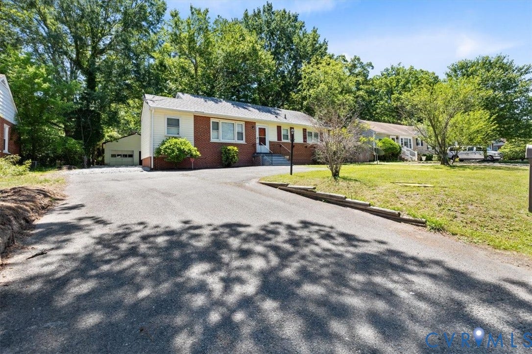 1215 Starling Drive, Henrico, VA 23229 Brick and siding exterior with a pitched roof, front yard with mature landscaping, and an asphalt driveway leading to a detached garage