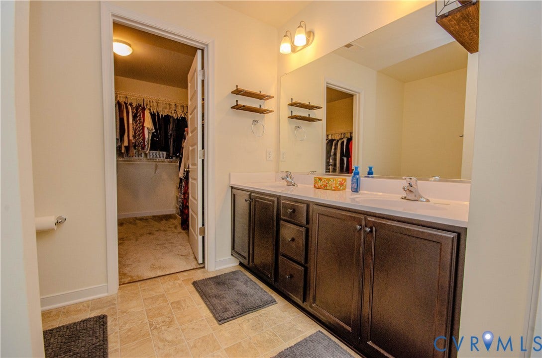 Double vanity with dual undermount sinks, chrome fixtures, and dark wood-finish cabinetry