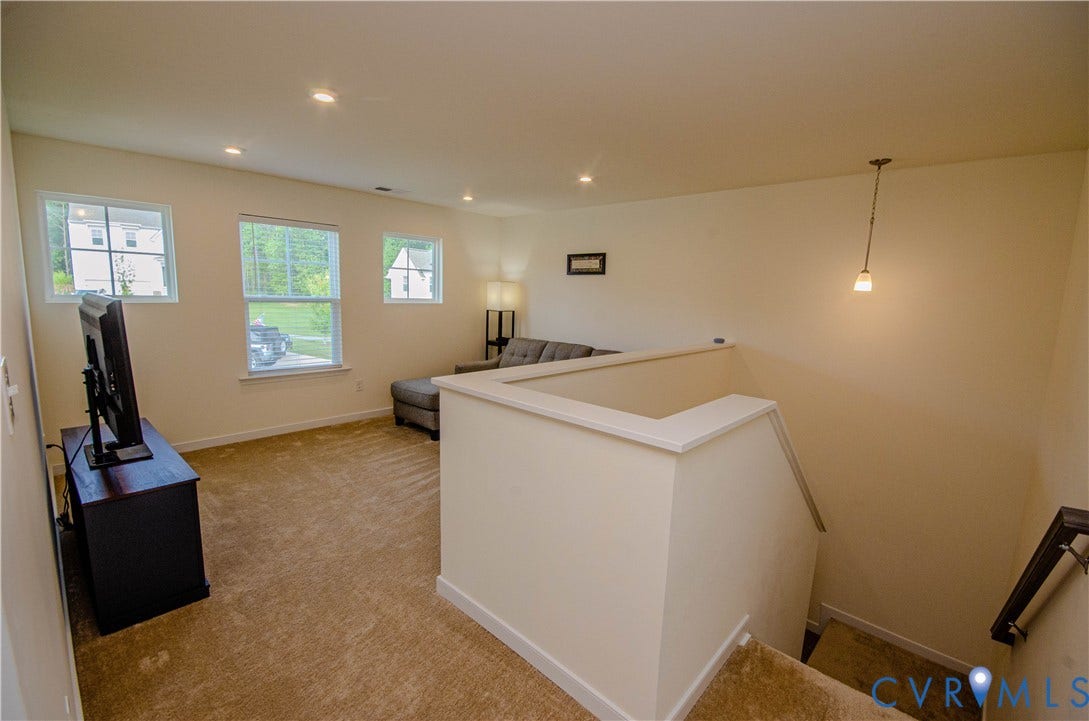 Plush carpet flooring, recessed lighting, and multiple windows with blinds