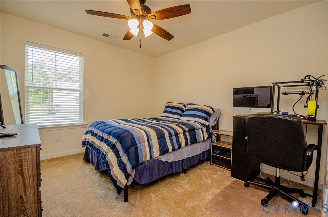 Carpeted flooring with a ceiling fan, a window with blinds, and neutral wall tones