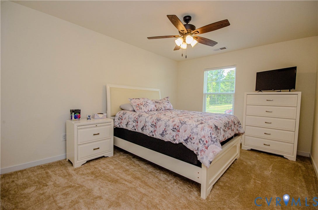 Carpeted flooring, ceiling fan with integrated lighting, a window with blinds, and walk-in closet