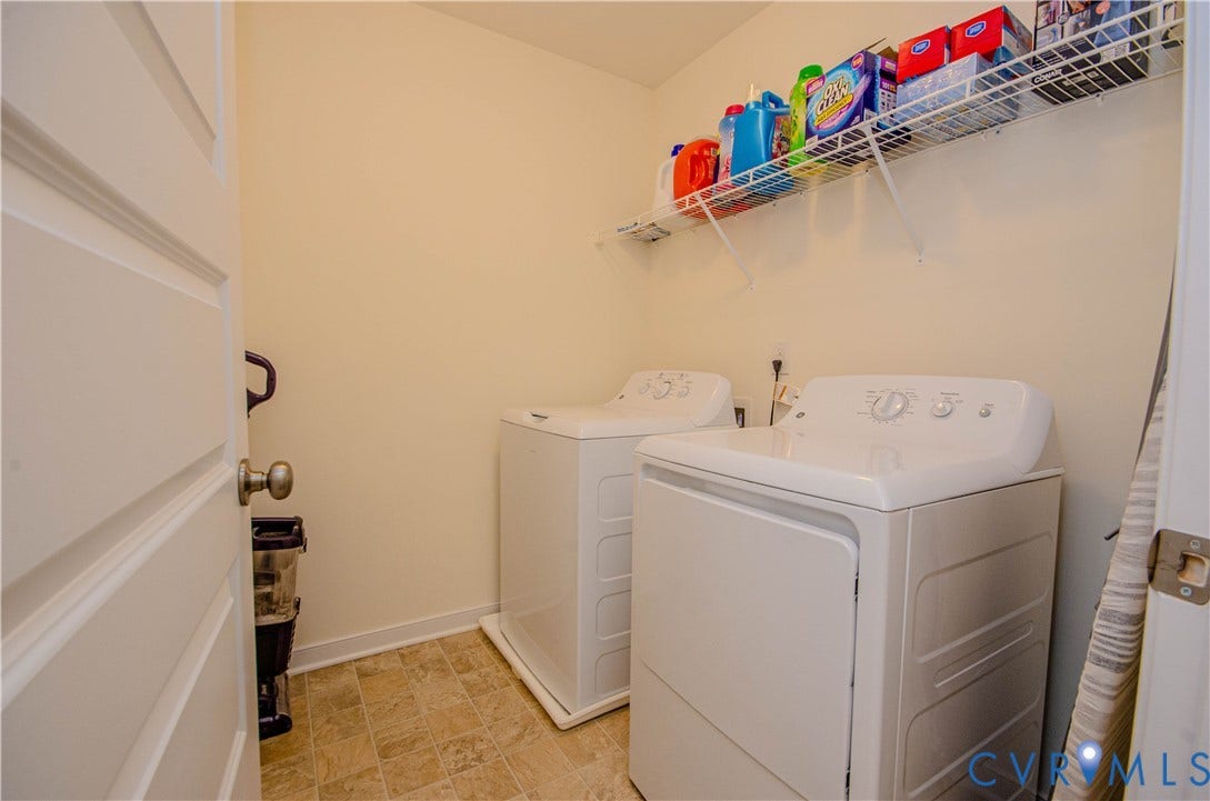 Laundry area featuring a wire storage shelf, light-toned wall paint, and durable flooring