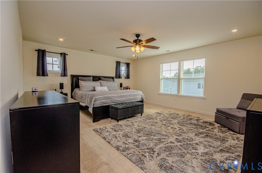 Recessed lighting, plush carpeting, ceiling fan with light fixture, multiple windows with blinds, and light-toned wall paint