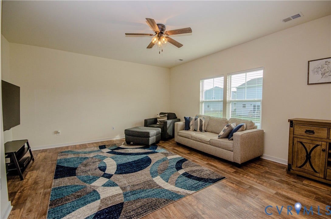 Vinyl flooring with ceiling fan and neutral wall tones