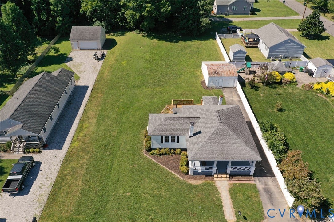 10024 Washington Road, Richmond, VA 23060 Expansive green space featuring two detached structures, a main residence with a covered porch, and a gravel driveway