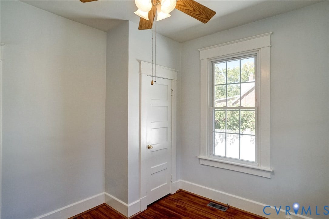 10024 Washington Road, Richmond, VA 23060 Hardwood flooring, multi-pane window with white trim, white paneled door, and a ceiling fan with light fixture